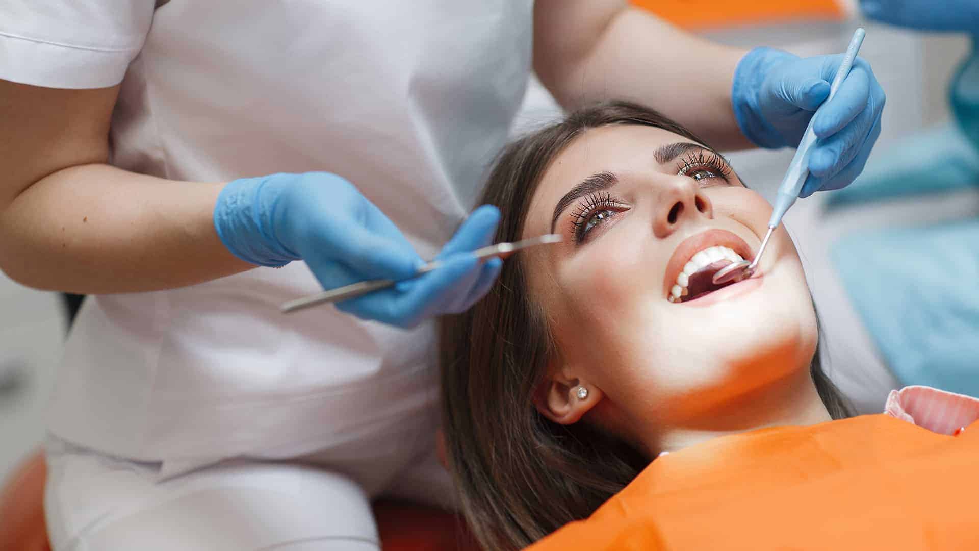 Dentist Using Mirror to Look at Fillings